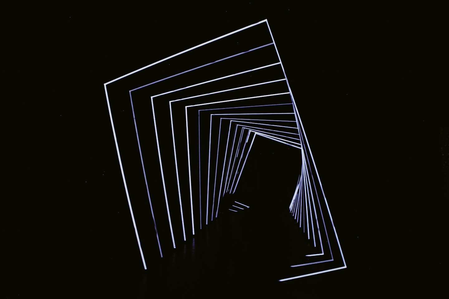 Glowing white and blue geometric lines form a digital tunnel.